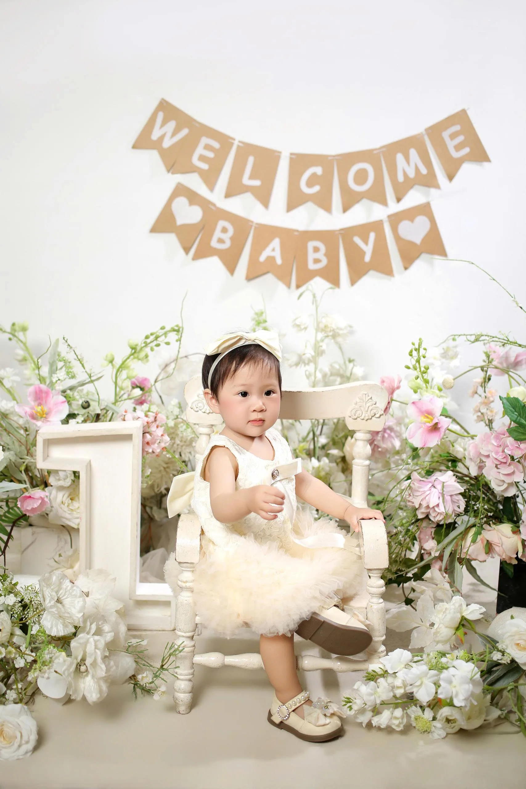 Dưa Hấu ngồi trên ghế trắng giữa hoa