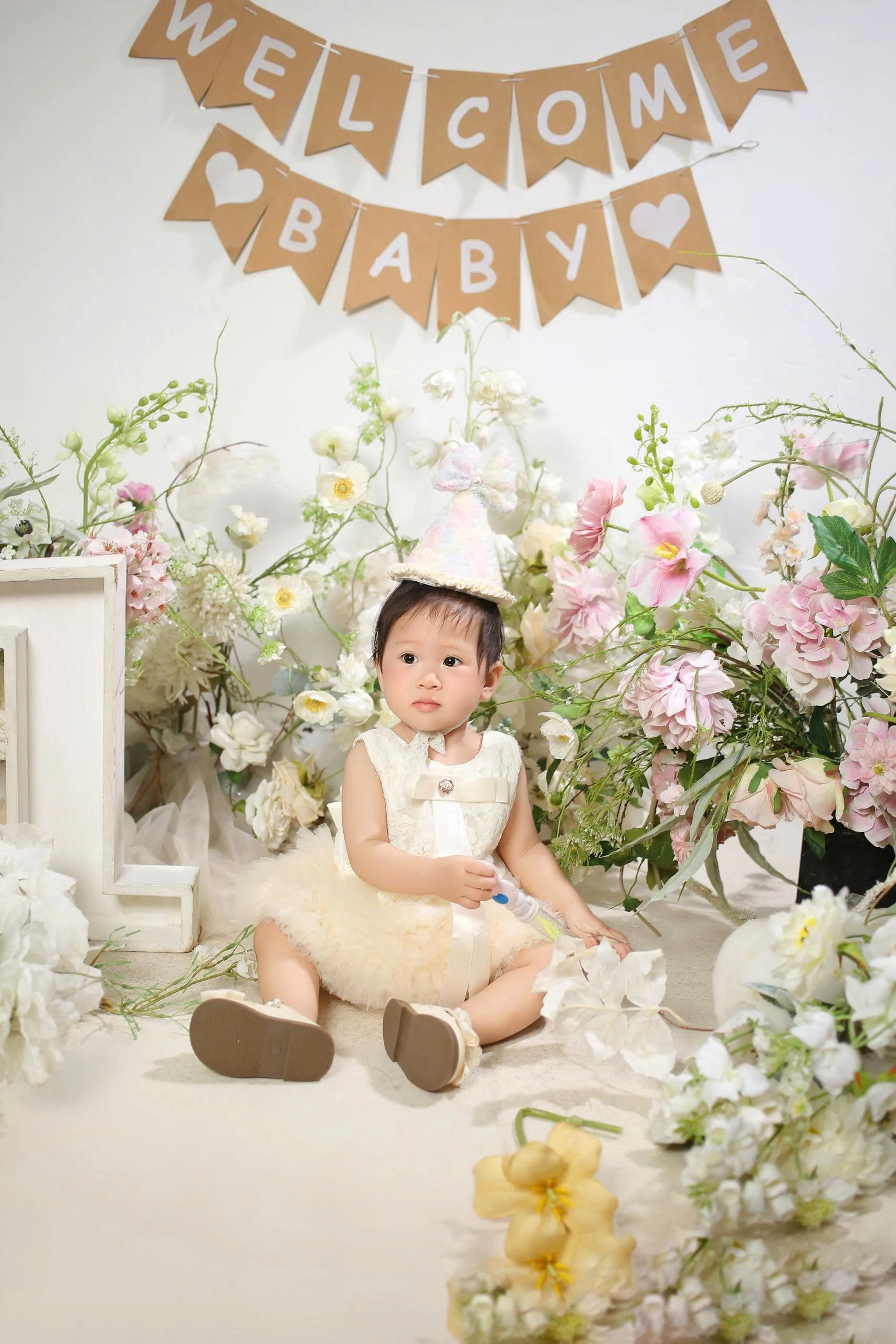 Dưa Hấu ngồi bên bảng welcome baby